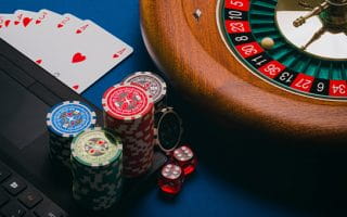 A Laptop and Casino Equipment on a Blue Surface