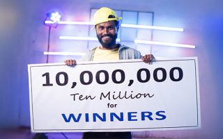 An image of a jackpot winner with a large cheque